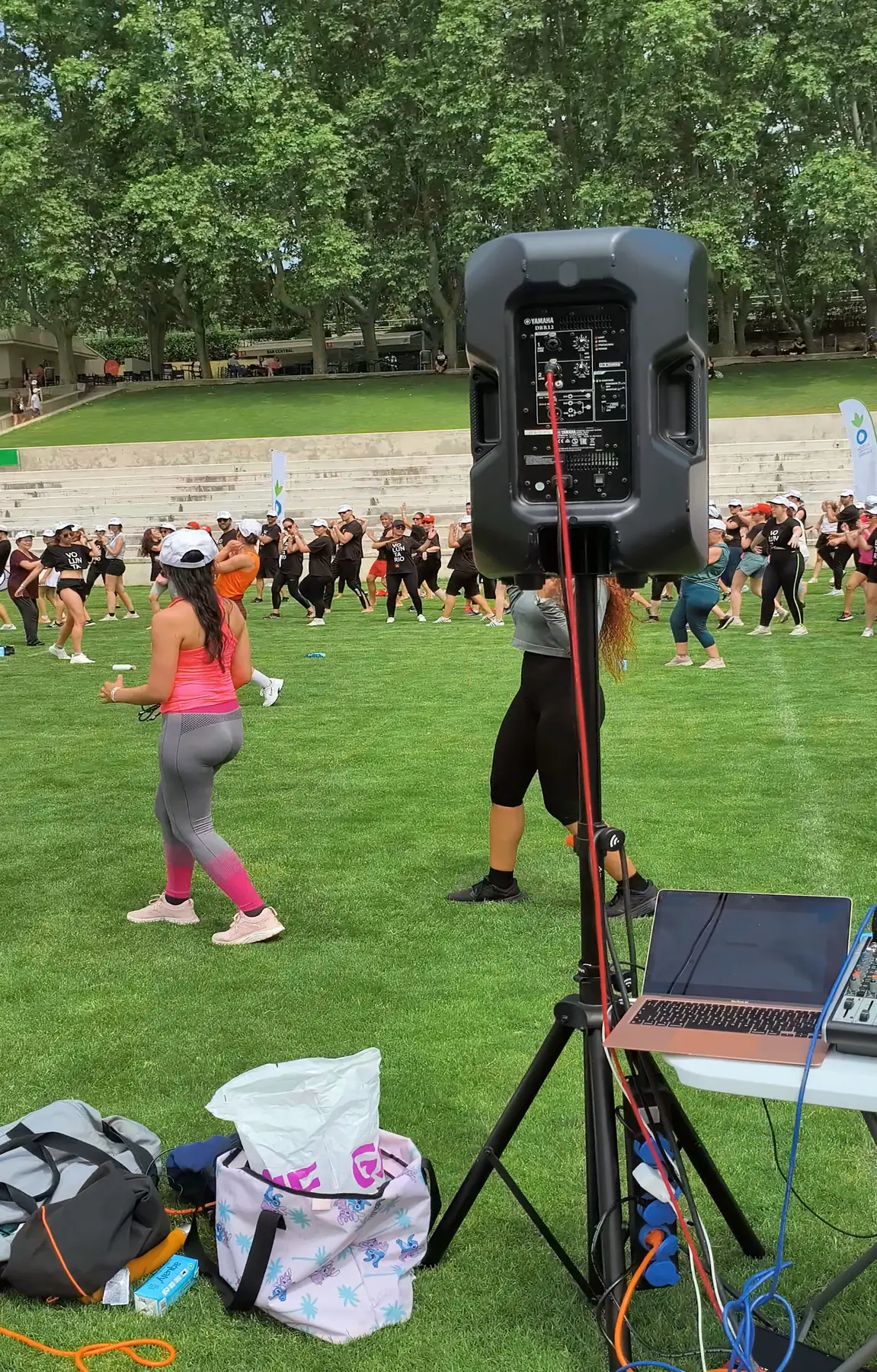 Altavoz en trípode y mesa de control con la clase de zumba en marcha, en la jornada de Acción contra el Hambre