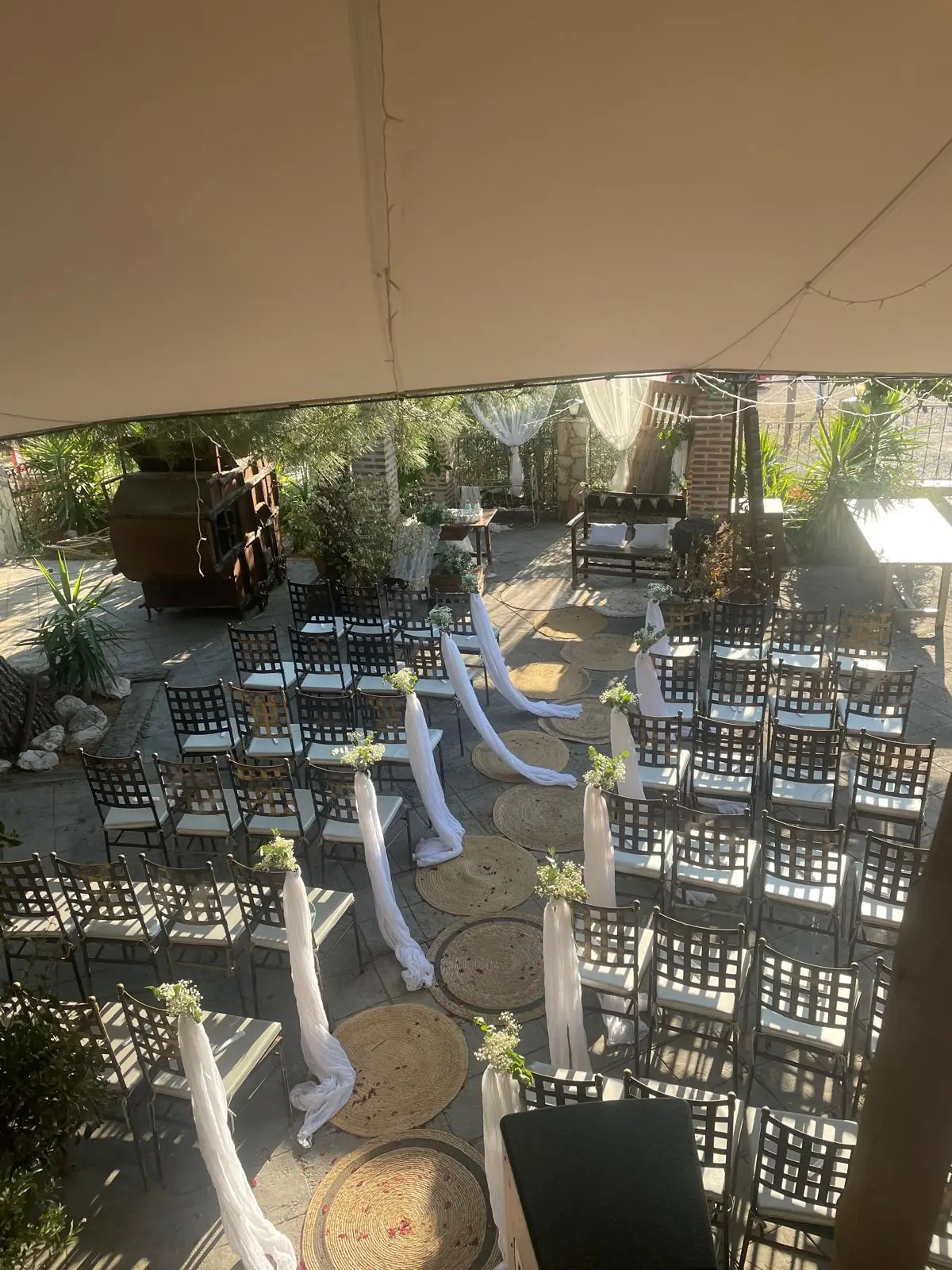 Sillas de la ceremonia preparadas bajo la carpa del jardín
