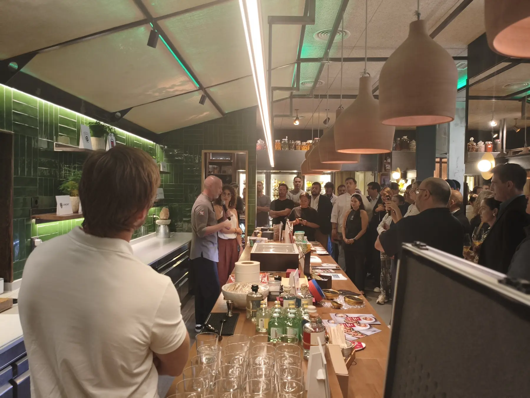 Presentación de la revista Foodie en El Invernadero: discurso con micrófono inalámbrico ante la sala llena