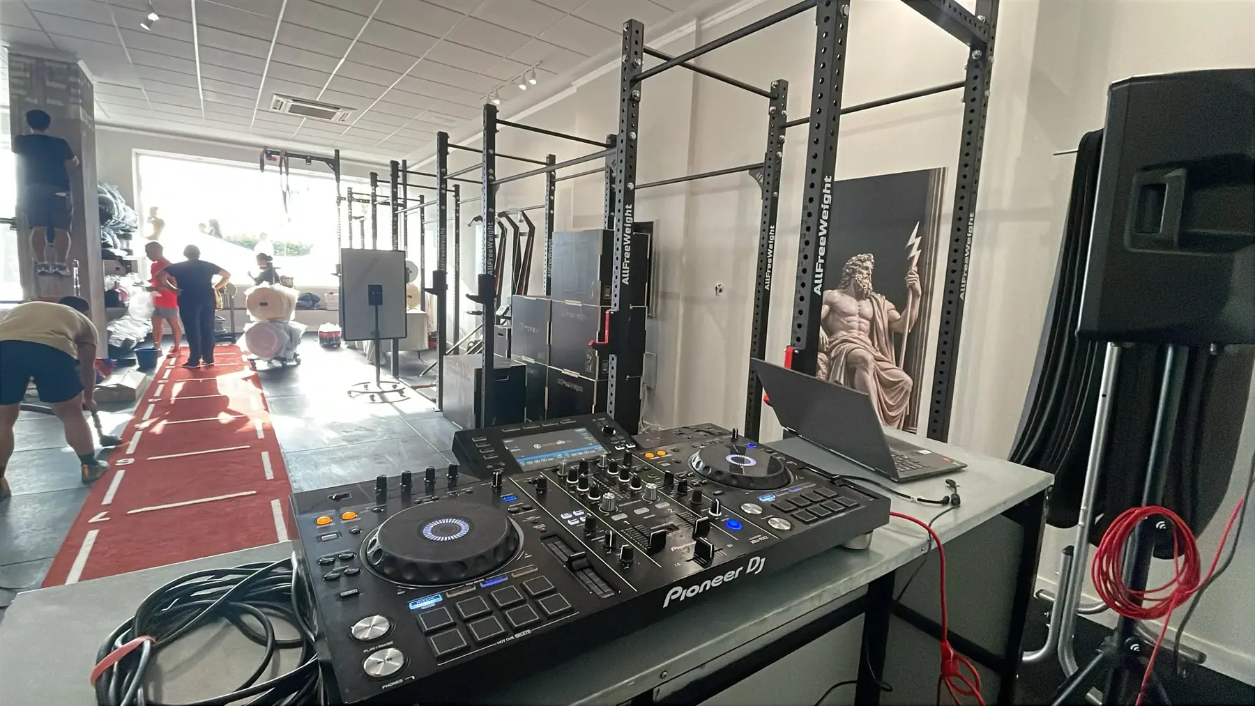 La controladora Pioneer de la cabina, con la sala de entrenamiento al fondo